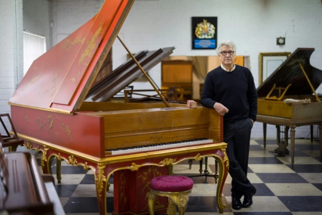 David Wilson, collectionneur et restaurateur de pianos, à côté d'un rare piano Pleyel datant de 1925, dans son atelier de Biddenden, le 6 août 2021 dans le sud-est de l'Angleterre