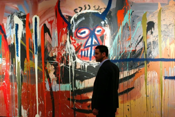 Loic Gouzer de Christie's passe devant la toile "sans titre" de Bsquiat le 29 avril 2016 lors d'une présentation à la presse à New York