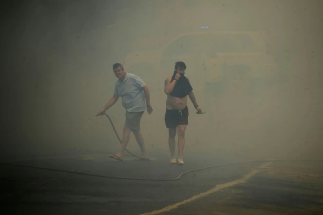 Des habitants se protègent des fumées lors d'un incendie de forêt à Mazagon, près d'un parc naturel dans le sud-ouest de l'Espagne, le 25 juin 2017 