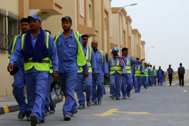 Des travailleurs immigrés de retour d'un site de construction du Mondial 2022 au Qatar, le 4 mai 2015 à Doha
