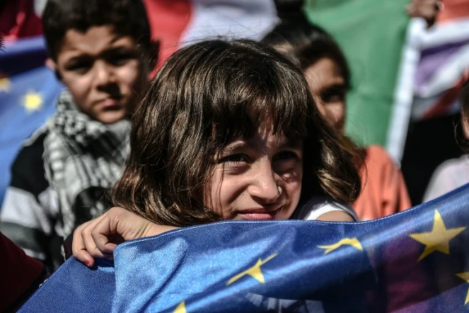 Une jeune migrante brandit un drapeau européen lors d'une manifestation de réfugiés à Istanbul, en Turquie, le 19 septembre 2015