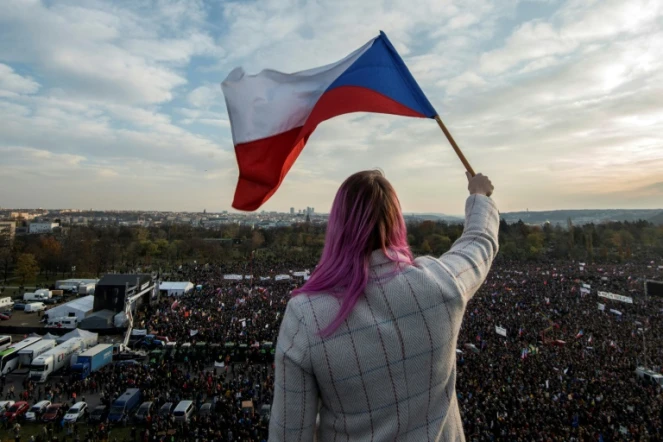 Une femme agite un drapeau en surplomb de la manifestation au centre de Prague de Tchèques qui réclament la démission de leur Premier ministre le 16 novembre 2019