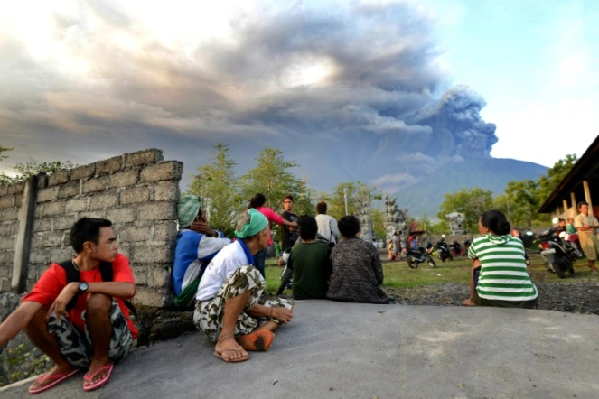 Des Balinais regardent l'épaisse fumée s'échapper du volcan du Mont Agung, le 26 novembre 2017 à Karangsem, sur l'île indonésienne de Bali