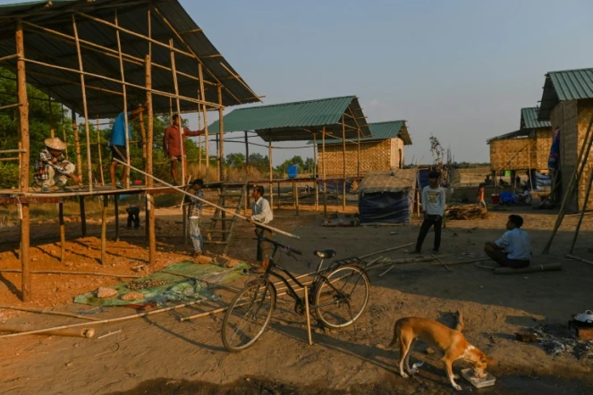 Des membres de l'ethnie Chin construisent une maison dans le village de Bethel, dans la banlieue de Rangoun, le 11 janvier 2021 en Birmanie
