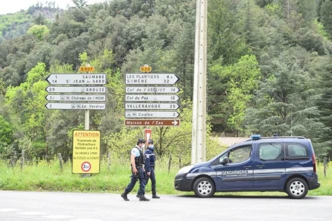 Des gendarmes à un carrefour près du village Les Plantiers dans les Cévennes, le 11 mai 2021 à la recherche d'un homme qui a tué son patron et un collègue