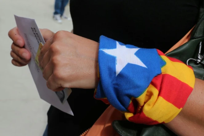 Une femme, un foulard indépendantiste au poignet, dans un bureau de vote de Badalona en Espagne, le 27 septembre 2015 