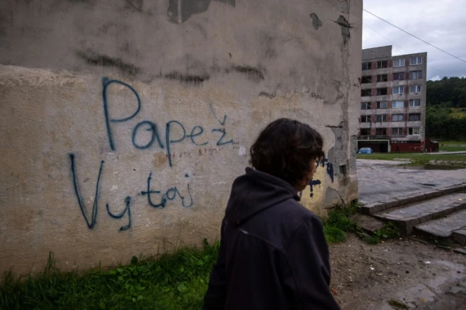 Une femme passe devant un mur portant l'inscription "Pape, bienvenue" dans le quartier Lunik IX de Kosice (Slovaquie), le 30 août 2021