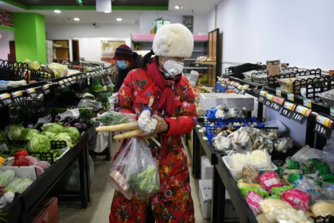 Une femme portant un masque de protection contre le coronavirus fait ses courses à Pékin le 16 février 2020