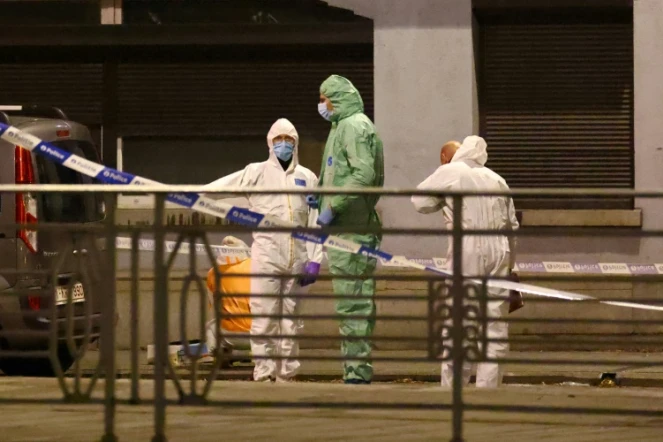 Des policiers belges mènent les investigations sur le lieu d'un attentat à Bruxelles où deux personnes de nationalité suédoise ont été tuées par un homme armé qui a pris la fuite en scooter le 16 octobre 2023