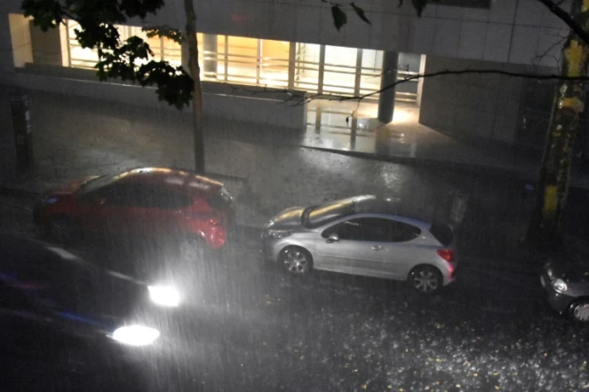 Des automobilistes conduisent sus la pluie dans le 20e arrondissement à Paris le 9 juillet 2017