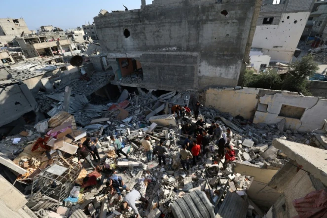 Des Palestiniens recherchent des survivants dans les décombres d'un bâtiment touché par une frappe israélienne à Bureij, dans le centre de la bande de Gaza, le 2 mai 2025
