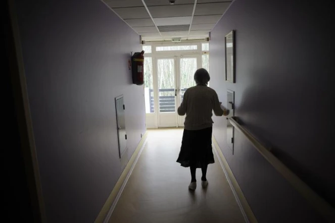 Une femme souffrant de la maladie d'Alzheimer marche dans le couloir d'une maison de retraite à Angervilliers, au sud-ouest de Paris, le 18 mars 2011