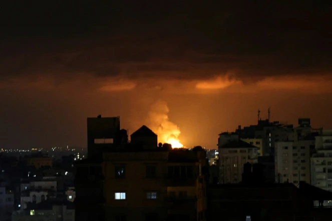 De la fumée et des flammes s'élèvent au-dessus de bâtiments après une frappe aérienne israélienne sur la bande de Gaza, le 9 mai 2023