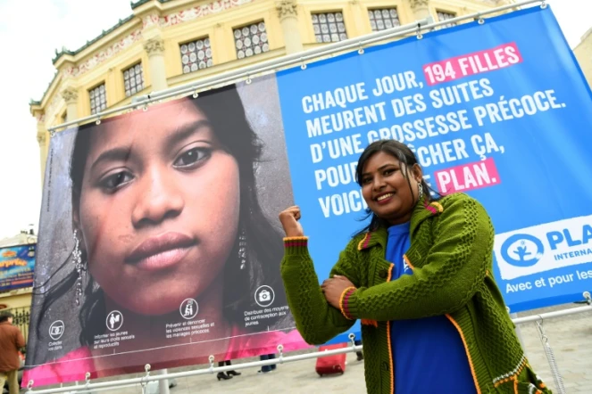 Radha Rani porte-parole de l'ONG Plan international, poses devant une affiche pendant l'inauguration d'une "Place du Calvaire des Filles" devant le Cirque d'Hiver à Paris le 10 octobre 2016