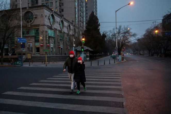 Des passants à Pékin le 28 janvier 2020 protégés par un masque 