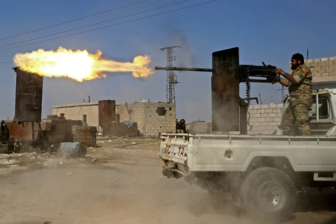 Un combattant syrien proturc tire à la mitrailleuse lors de combats dans la ville de Ras al-Aïn dans le nord de la Syrie, le 13 octobre 2019 