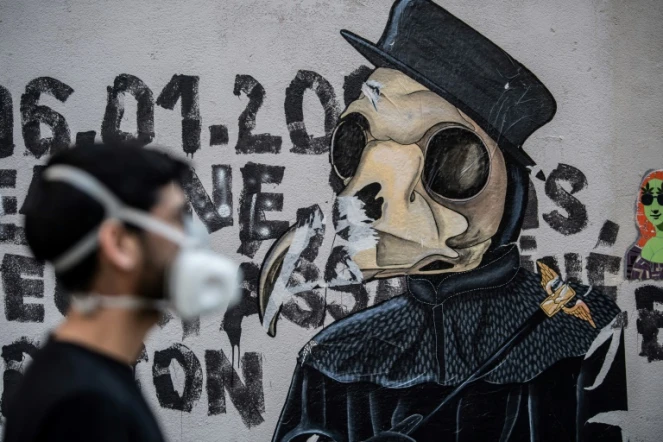 L'artiste Angel Crow devant une de ses oeuvres, dans une rue à Paris, le 22 avril 2020