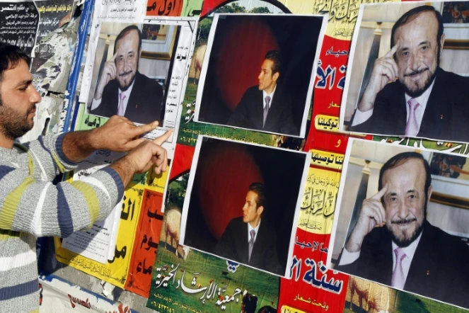 Un homme colle des affiches de Rifaat al-Assad, l'oncle du président syrien, le 6 décembre 2007 à Tripoli 