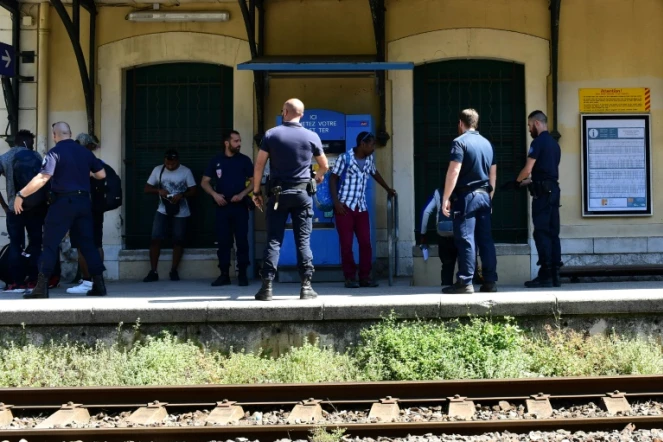 Des policiers contrôlent des migrants qui ont traversé la frontière avec l'Italie, le 14 juin 2018 à la gare de Menton