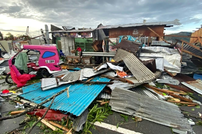 Habitant cherchant des affaires personnelles dans des débris après le passage du typhon Rai dans la ville philippine de Surigao le 17 décembre 2021