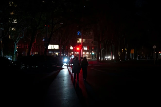Des piétons dans une rue obscure à Barcelone, en Espagne, pendant une panne d'électricité massive affectant la péninsule ibérique et le sud de la France, le 28 avril 2025