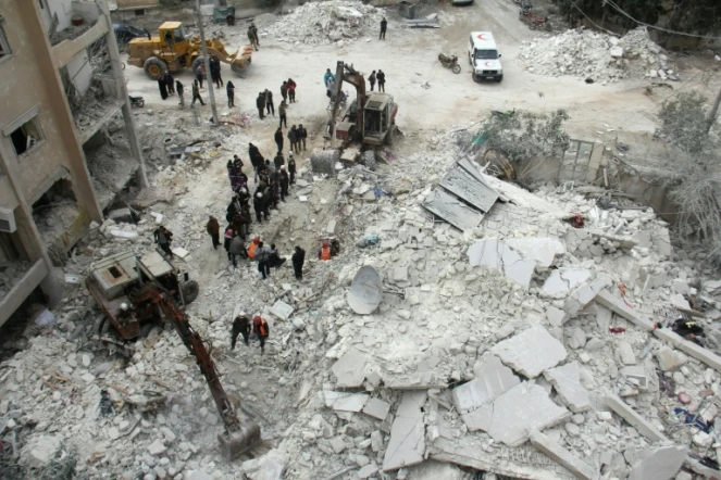 Des Casques blancs syriens recherchent des victimes dans les décombres d'un immeuble après un bombardement à Idleb, le 15 mars 2017