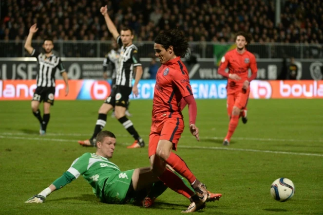 L'avant-centre du PSG Edinson Cavani bute sur le gardien Ludovic Butelle du SCO d'Angers au stade Jean-Bouin, le 1er décembre 2015