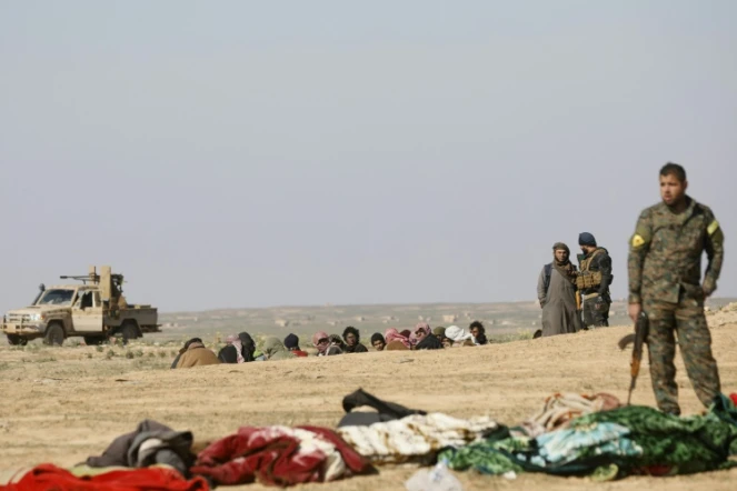 Un combattant des Unités de protection du peuple (YPG) kurdes attend le démarrage d'une fouille de prisonniers, près de Baghouz, en février 2019