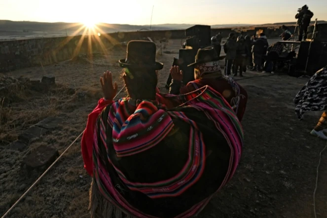 Des Indiens Aymaras lèvent les paumes au ciel pour recevoir les premiers rayons du soleil lors de la célébration du Nouvel An Aymara à Tiwanaku, en Bolivie, le 21 juin 2022