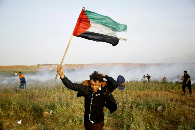 Un Palestinien brandissant un drapeau lors d'une manifestation à la frontière entre la bande de Gaza et Israël le 4 avril 2018