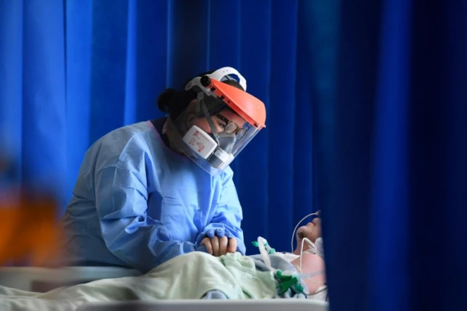 Une soignante réconforte un patient atteint par le Covid-19 dans un hôpital de Cambridge, le 5 mai 2020 au Royaume-Uni