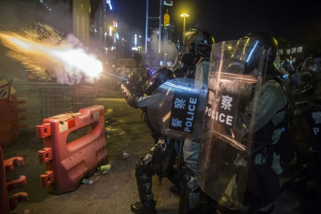 Des policiers tirent des canettes de gaz lacrymogène lors d'une manifestation à Hong Kong, le 4 août 2019