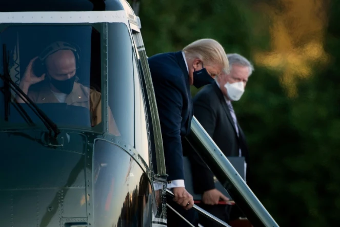 Le chef de cabinet de la Maison Blanche Mark Meadows (d) surveille le président Trump qui descend de l'hélicoptère pour arriver à l'hôpital militaire Walter Reed à Bethesda (Maryland), le 2 octobre 2020