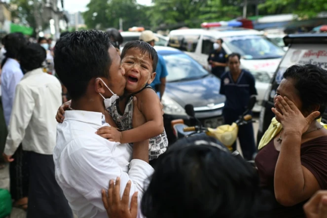 Un homme retrouve sa famille après sa remise en liberté à la faveur d'une amnistie décidée par la junte birmane, devant la prison d'Insein à Rangoun le 19 octobre 2021