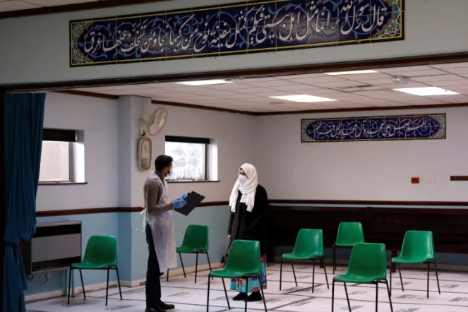 Une femme parle avec un soignant avant de se faire vacciner au centre islamique Al-Abbas, converti en centre de vaccination, à Birmingham, le 21 janvier 2021