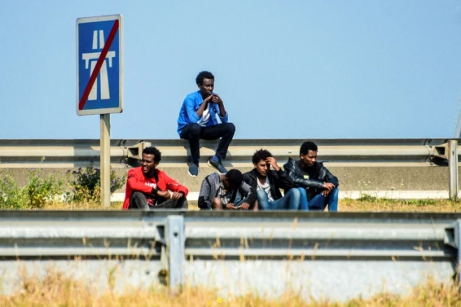 Des migrants sur la route menant au port de Calais le 21 juin 2017