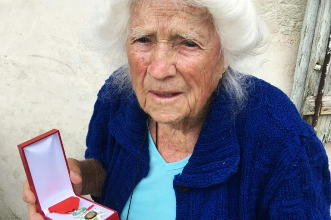 Geneviève Callerot, 102 ans, pose le 25 août 2018 à Saint-Aulaye (Dordogne), avec sa Légion d'honneur dont elle a été décorée pour avoir fait passer en zone libre réfugiés et juifs durand la 2nde Guerre mondiale  