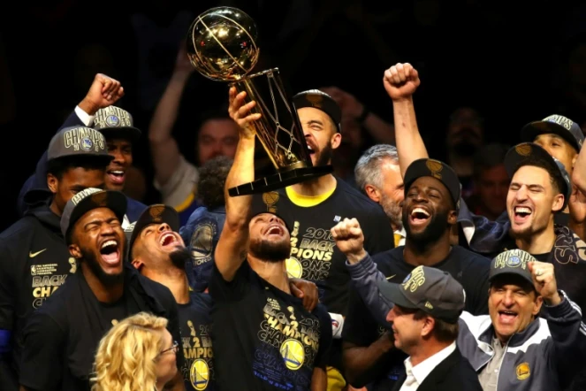 Les Golden State Warriors fêtent leur 3e titre NBA après leur victoire sur les Cavaliers lors du match 4 de la finale, à Cleveland, le 8 juin 2018