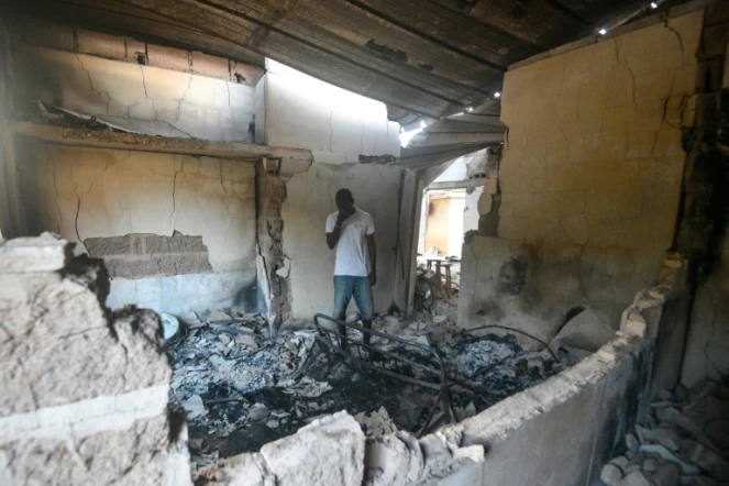 Un habitant de Toumodi, dans le centre de la Côte d'Ivoire, se tient dans sa maison brûlée lors d'échauffourées liées à la présidentielle, le 3 novembre 2020.