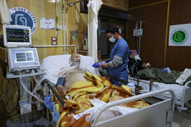 Un infirmier au chevet d'un patient le 16 janvier 2022 dans l'hôpital de Darkouch, dans le nord-ouest de la Syrie