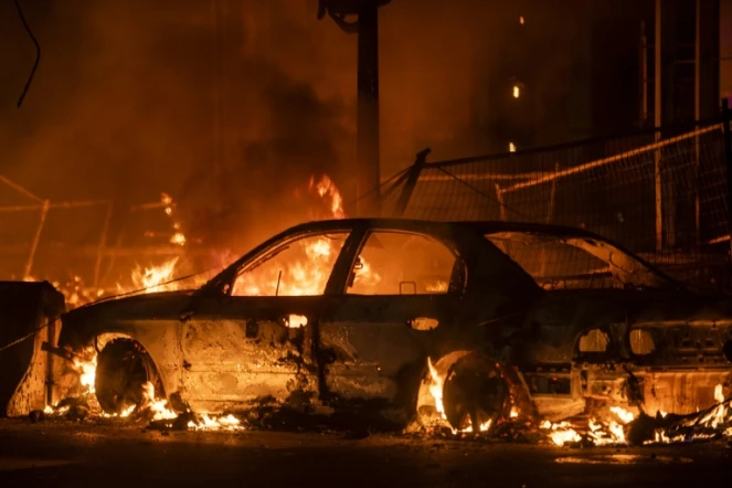 Une voiture incendiée lors de heurts entre la police et des manifestants à Minneapolis le 27 mai 2020, suite à la mort d'un homme nor suite à son interpellation musclée