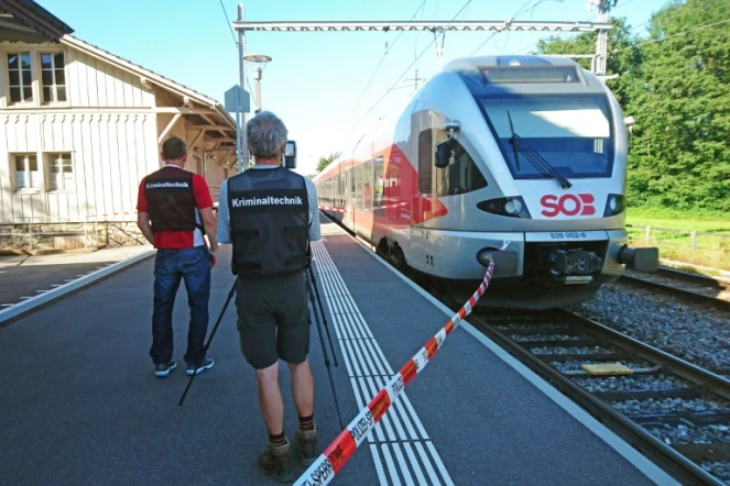 Des policiers aux abords d'un train à la station de Salez (est de la Suisse) après qu'un homme a mis le feu à un wagon et poignardé des passagers, le 13 août 2016 