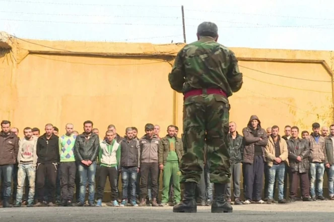 Le chef de la police militaire d'Alep s'adresse à un groupe d'hommes détenus dans une base militaire à Alep, le 11 décembre 2016