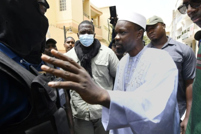 Le leader de l'opposition Ousmane Sonko parle avec des policiers devant chez lui, le 17 juin 2022 à Dakar, au Sénégal