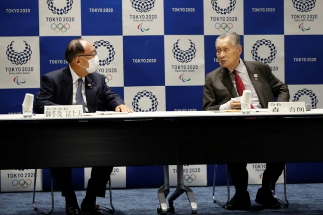 Le président du comité d'organisation des JO-2020 de Tokyo Yoshiro Mori en discussion avec le président honoraire Fujio Mitarai, masqué, avant une conférence de presse le 30 mars 2020 à Tokyo