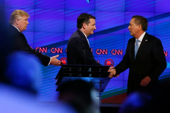 Donald Trump (g), le sénateur du Texas Ted Cruz (c), et le gouverneur de l'Ohio, John Kasich, se serrent la main après un débat sur la chaîne CNN, à Miami, en Floride, le 10 mars 2016