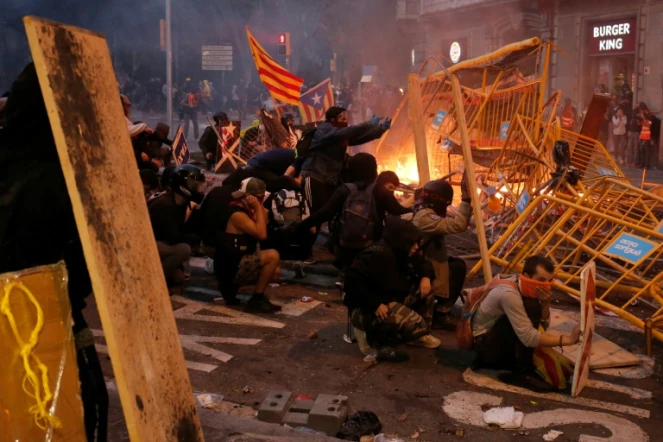 Des manifestants dressent des barricades lors de heurts avec les forces de l'ordre, à Barcelone le 18 octobre 2019

