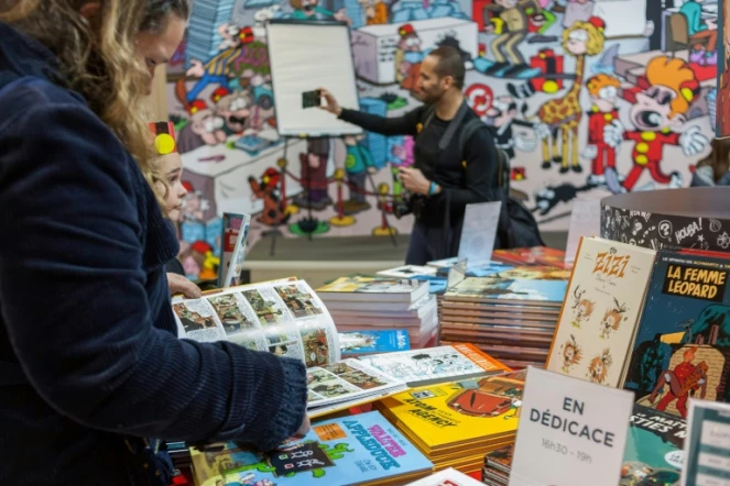 Une lectrice est plongée dans une bande-dessinée lors de la 46e édition du festival de BD d'Angoulême le 24 janvier 2019