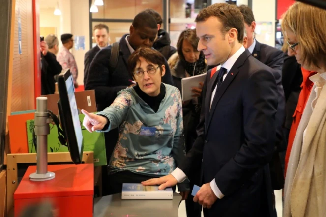 Le président de la République Emmanuel Macron (c) et la ministre de la Culture Françoise Nyssen (d) à la médiathèque des Mureaux (Yvelines) le 20 février 2018
