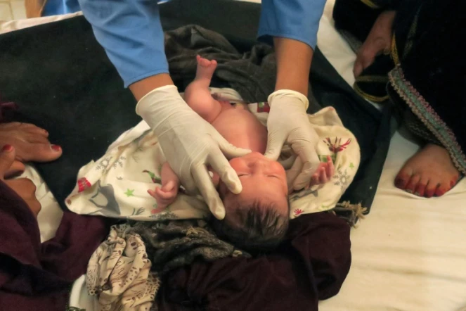 Une sage-femme afghane de Médecins sans Frontières (MSF) vérifie l'état de santé d'un nouveau-né dans une maternité, le 8 août 2018 à Khots, en Afghanistan